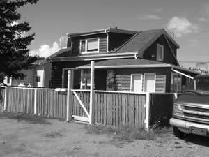 The Firth House is 1 1/2-storey original log structure with a gable roof. Asphalt roof shingles and log siding cover the exterior of the building. 