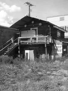 Mah Bing building is a two storey partially squared log structure with log roof beams and a gable roof covered in galvanized sheet metal. It also has timber grade beam footing with no basement.
