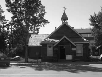 The Old Log Church is a log building with an L-shaped plan and a gable roof. The interior consists of stick frame trusses and the roof is covered with cedar shingles. 