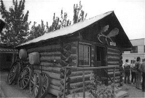 Sam McGee's Cabin is a one room log cabin with a frame gabled roof and corrugated metal roof sheathing.