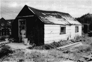 The Sewell House is a wood frame constructed over tent frame with a gable roof. It has horizontal wood siding and roll asphalt roofing. The approximate size is 12′ by 24′