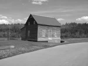 The Chambers House is a two-storey log structure with frame gable roof. The exterior has aluminum siding covering the log walls. The foundation is a timber frame sill and the roof is covered with asphalt shingles. 