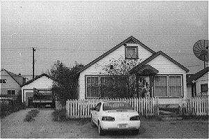 The Earle House is a 1-1/2 storey frame residence which includes a foundation and basement. A gable roof is covered with asphalt shingles. The exterior is covered by asbestos shingles.