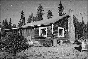 Langholtz house is a log building with a gable standing seam metal roof. Several additions including a log addition to north façade with a shed roof and a porch addition to west façade were constructed.