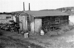 Red Roy Piercy Cabin is a one room log structure with a low sloped gable roof. The building rests on an unstable wood sill foundation. 