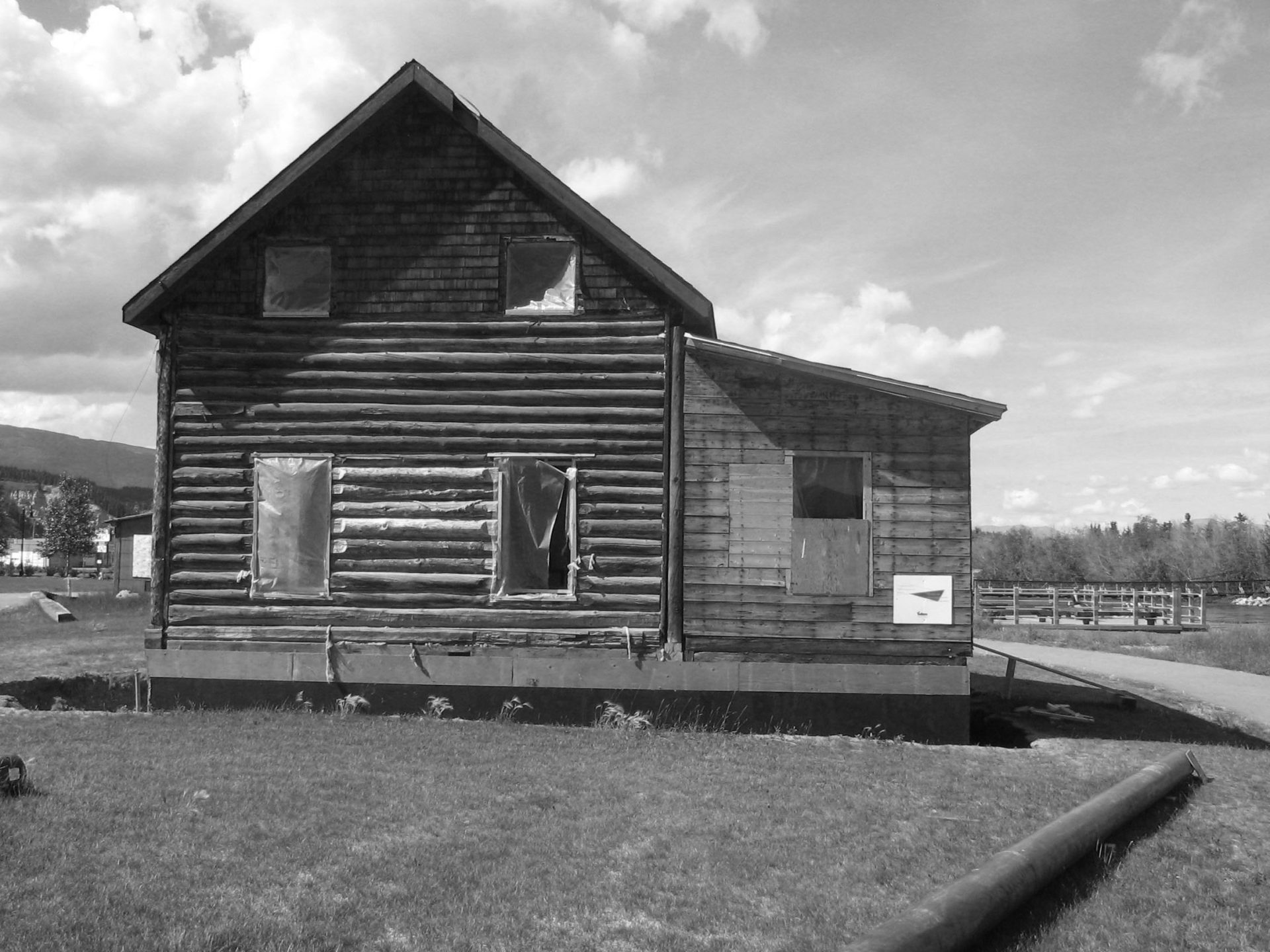 The Chantler log house had a T-shaped plan and metal hip roof throughout except for a gable roof over the bay window in the front facade. 